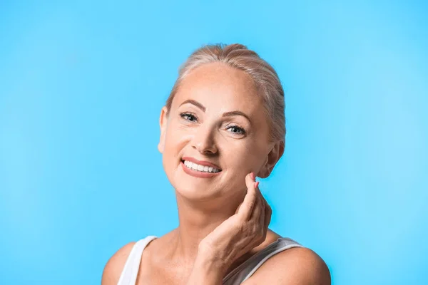 Retrato de hermosa mujer madura con piel perfecta sobre fondo azul claro —  Fotos de Stock