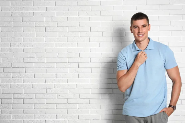 Portrait of handsome young man on white brick wall. Space for text — Stock Photo, Image