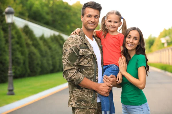 Homem de uniforme militar com sua família no parque ensolarado — Fotografia de Stock