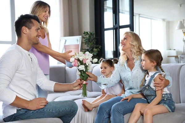 Szczęśliwa rodzina z małymi dziećmi gratuluje dojrzałej kobiecie w salonie — Zdjęcie stockowe