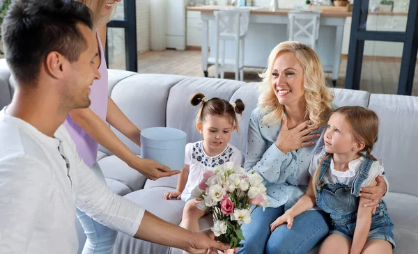 거실에서 성숙한 여성을 축하하는 어린 아이들과 행복한 가족 — 스톡 사진