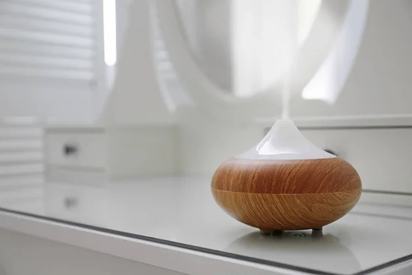 Etherische oliën diffuser op witte tafel in de kamer. Ruimte voor tekst — Stockfoto