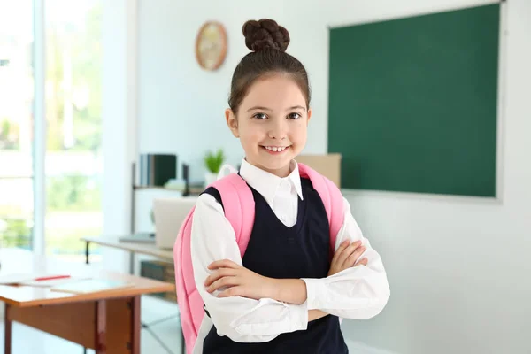 Ragazza che indossa uniforme scolastica con zaino in classe — Foto Stock