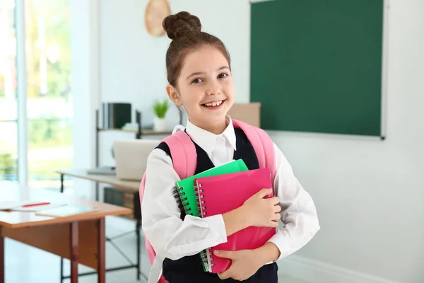 Dívka nosí školní uniformu s batohu ve třídě — Stock fotografie