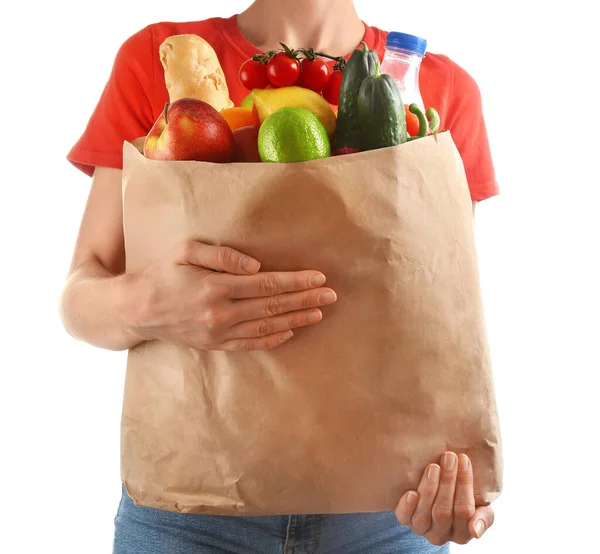 Žena drží papírový sáček s různými potravinami na bílém pozadí, detailní pohled — Stock fotografie