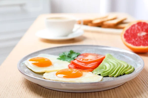 Teller mit Spiegeleiern und Gemüse auf Holztisch. gesundes Frühstück — Stockfoto