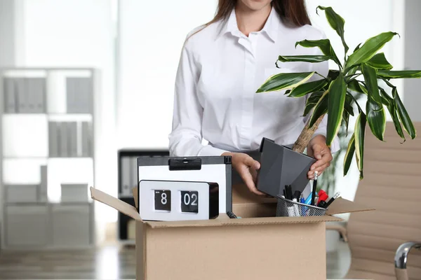 Молода жінка упаковує речі в коробку в офісі, крупним планом — стокове фото