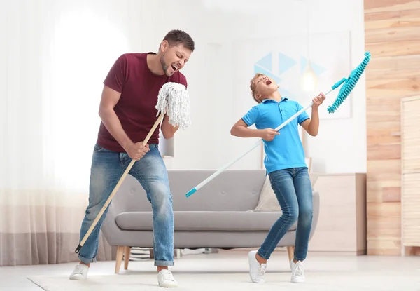 Dad and son having fun while cleaning living room together — Stock Photo, Image