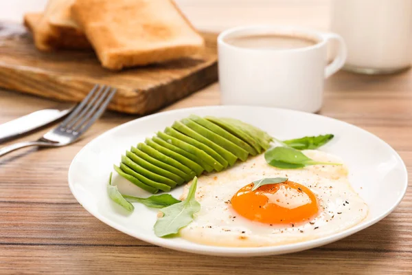 Leckeres Frühstück mit Spiegelei und Avocado auf Holztisch, Nahaufnahme — Stockfoto