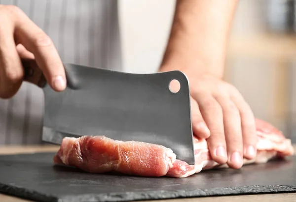 Hombre cortando carne fresca cruda en la mesa en la cocina, primer plano — Foto de Stock