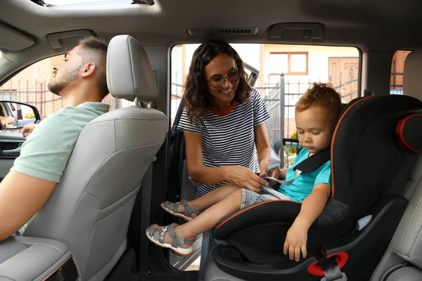 Frau schnallte ihren Sohn mit Sicherheitsgurt im Auto fest. Familienurlaub — Stockfoto