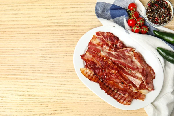 Rodajas de sabroso tocino frito en la mesa de madera, la puesta plana. Espacio para texto —  Fotos de Stock