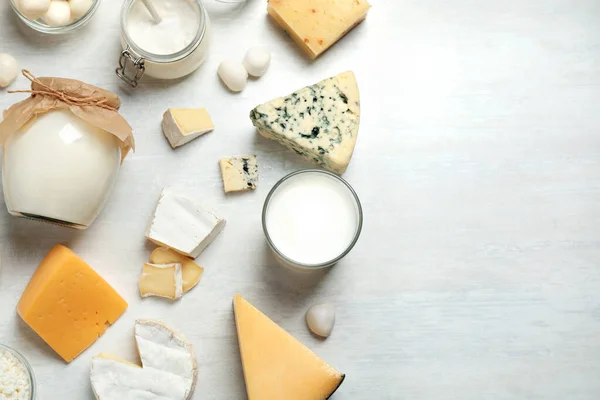 Diferentes deliciosos produtos lácteos na mesa branca, flat lay. Espaço para texto — Fotografia de Stock