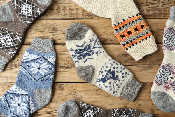 Verschiedene gestrickte Socken auf Holzgrund, flach liegend — Stockfoto