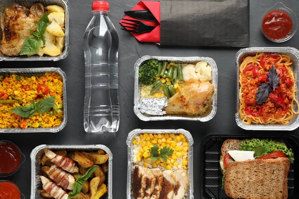 Lunchpakete auf grauem Tisch, flach gelegt. Lieferung gesunder Lebensmittel — Stockfoto
