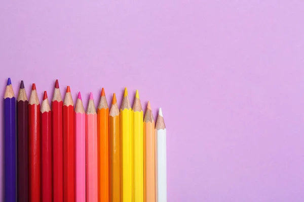 Lápis de cor sobre fundo lilás, flat lay. Espaço para texto — Fotografia de Stock