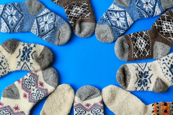 Cadre en chaussettes tricotées sur fond bleu, couché plat avec espace pour le texte. Vêtements d'hiver — Photo