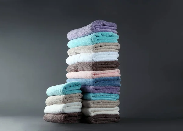 Różne świeże miękkie ręczniki frotte na szarym tle — Zdjęcie stockowe