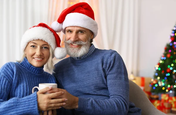 집에서 크리스마스를 축하하는 산타 모자의 행복한 커플 — 스톡 사진