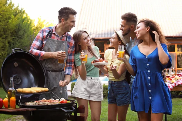 Grup de prieteni cu băuturi lângă grătar grătar în aer liber — Fotografie, imagine de stoc