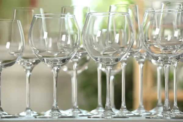 Empty glasses on table against blurred background — Stock Photo, Image