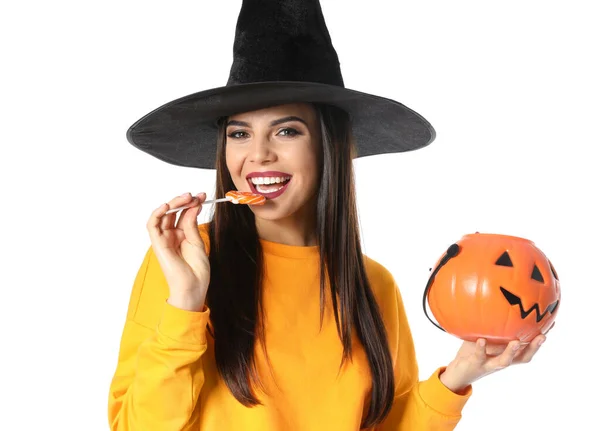 Mulher bonita vestindo traje de bruxa com Jack O 'Lantern recipiente de doces para festa de Halloween no fundo branco — Fotografia de Stock