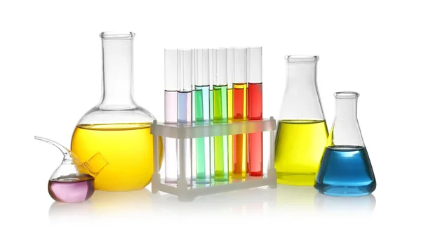 Laboratory glassware with colorful liquids on white background — Stock Photo, Image