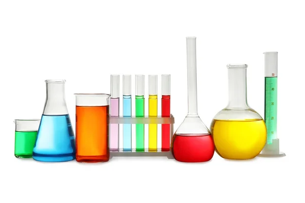 Artículos de vidrio de laboratorio con líquidos de colores sobre fondo blanco — Foto de Stock