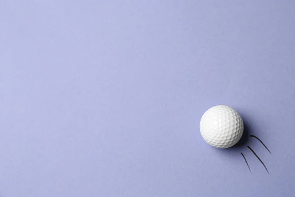 Bola de golfe voando sobre fundo lilás - imagem criativa. Vista superior — Fotografia de Stock