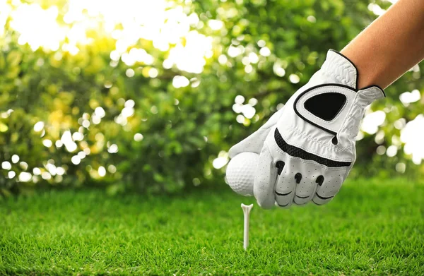 Jogador colocando bola de golfe no tee em campo verde, close-up — Fotografia de Stock