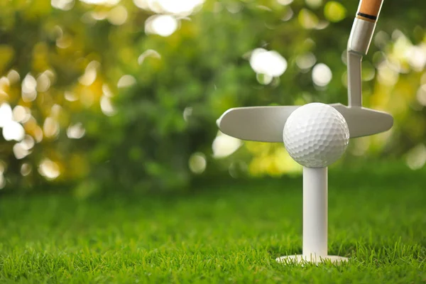 Bater bola de golfe com clube em campo verde — Fotografia de Stock