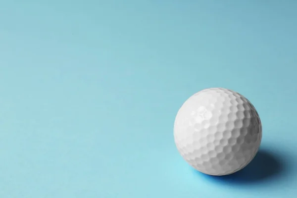 Golfbal op lichtblauwe achtergrond. Ruimte voor tekst — Stockfoto