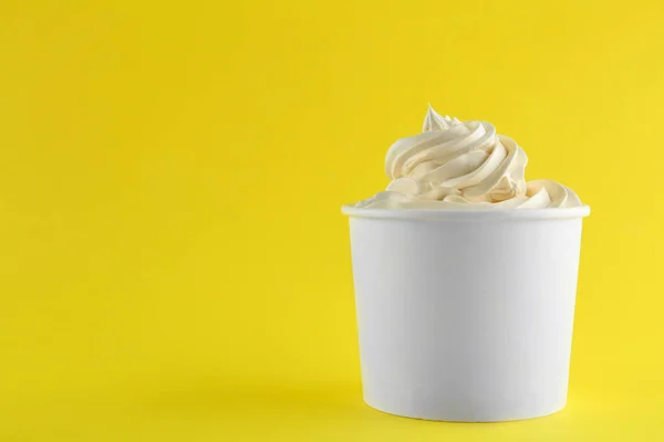 Kopp med välsmakande fryst yoghurt på gul bakgrund. Utrymme för text — Stockfoto