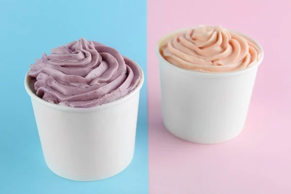 Cups with tasty frozen yogurts on color background — Stock Photo, Image