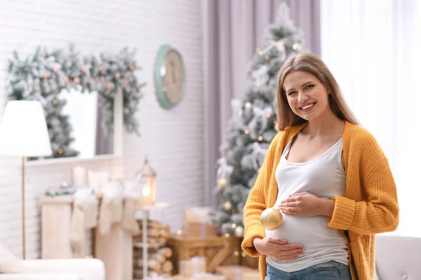 Młoda kobieta w ciąży z świąteczne dekoracje w domu — Zdjęcie stockowe