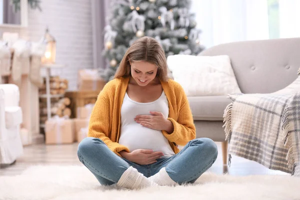 若いです妊娠中の女性のために飾られた部屋で床に座ってクリスマス — ストック写真