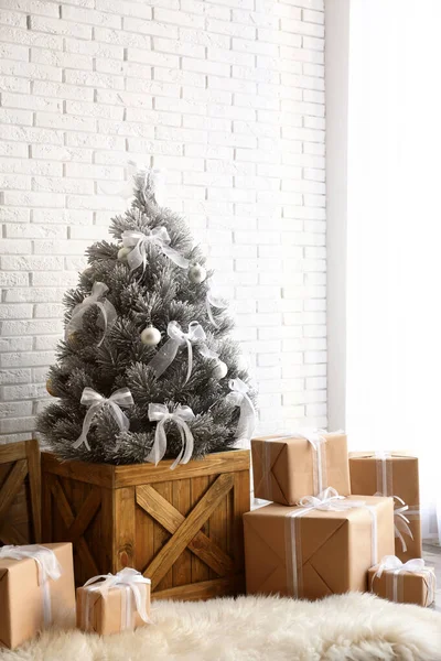 Stilvolles Interieur mit wunderschönem Weihnachtsbaum und Geschenken in der Nähe weißer Ziegelwand — Stockfoto