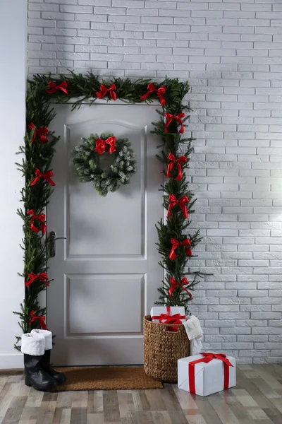 Intérieur élégant du couloir avec porte décorée et cadeaux de Noël — Photo