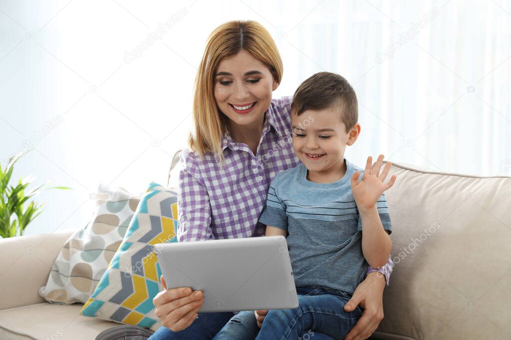 Mother and her son using video chat on tablet at home