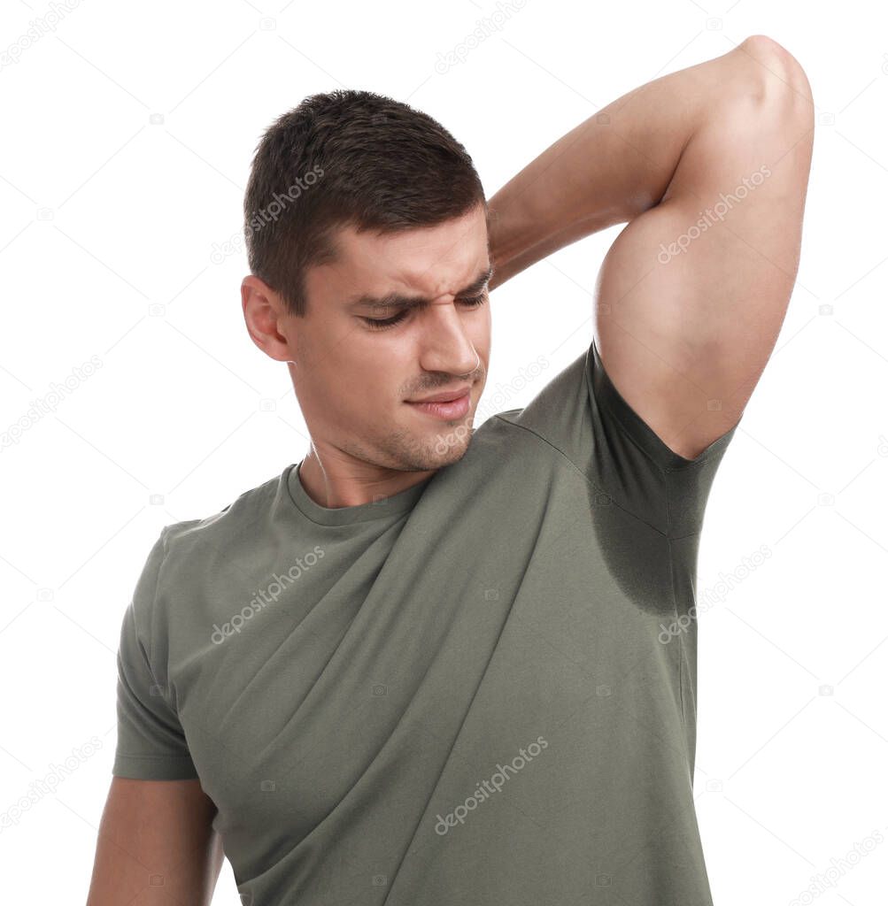 Young man with sweat stain on his clothes against white background. Using deodorant