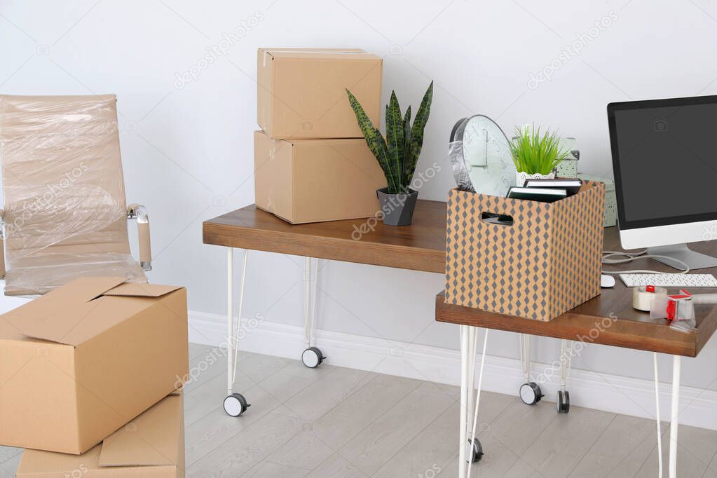Interior of modern office with packed belongings. Moving service