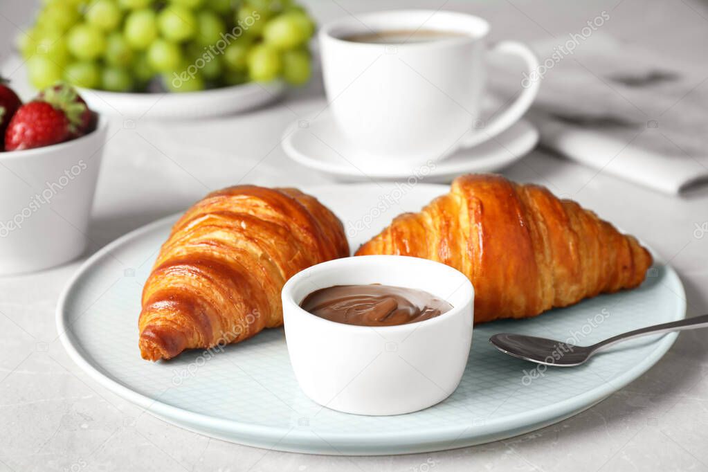 Delicious breakfast with croissants and chocolate served on light table