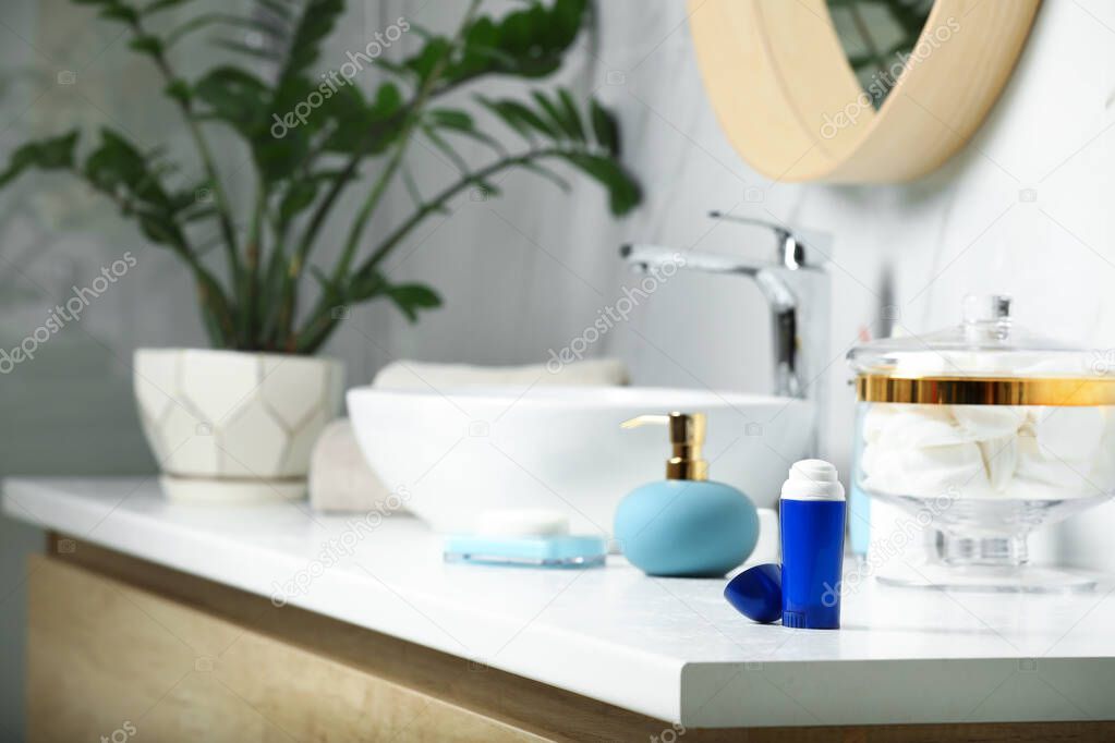 Stick deodorant and different toiletry on countertop in bathroom, space for text