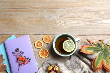 Düz kompozisyon, bir fincan sıcak içecekle ahşap masada, metin için boşluk. Sıcak sonbahar atmosferi