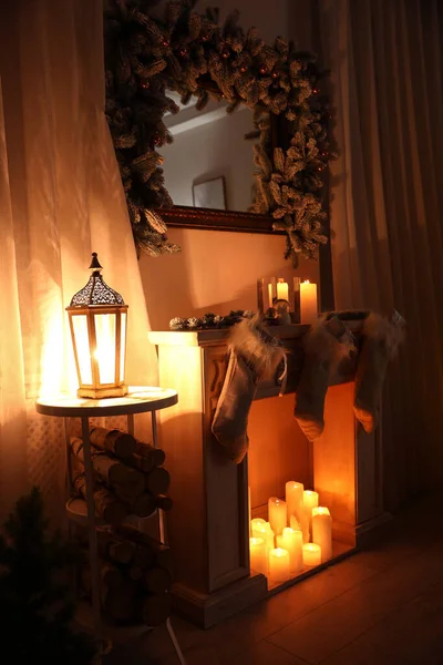 Stilvolles Weihnachtsinterieur mit dekorativem Kamin und brennenden Kerzen — Stockfoto