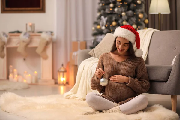 Szczęśliwa ciężarna kobieta ze świątecznym balem w domu. Spodziewamy się dziecka. — Zdjęcie stockowe
