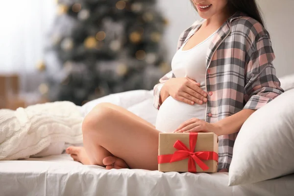 Mulher grávida feliz com caixa de presente de Natal na cama em casa, close-up. Bebê esperado — Fotografia de Stock