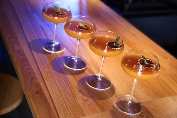 Glasses of delicious cocktail with vodka on wooden counter in bar — Zdjęcie stockowe