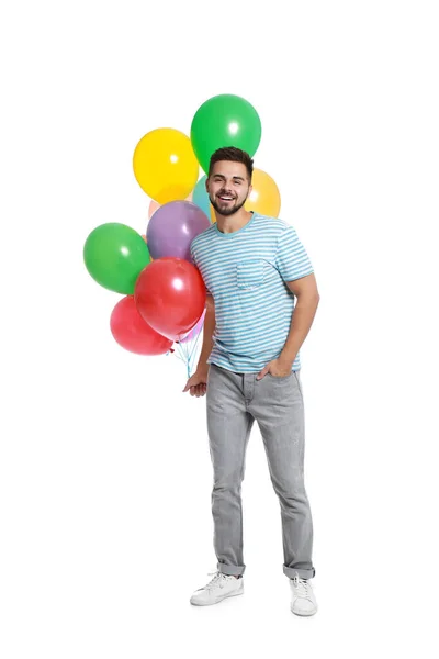 Jeune homme tenant un tas de ballons colorés sur fond blanc — Photo