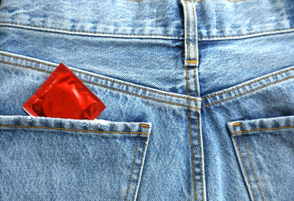Closeup view of jeans with condom in pocket. Safe sex concept